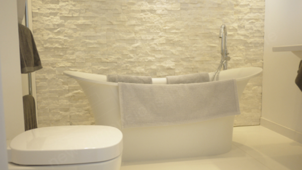 Kamar mandi dengan batu alam yang menjadi fokus utama desain